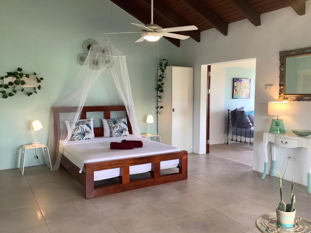 a bedroom with a bed and a ceiling fan at Villa San Sebastian Curaçao in Fontein