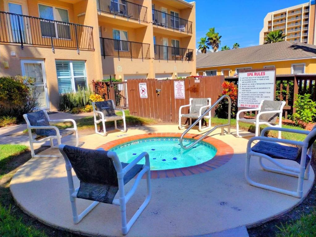 a patio with chairs and a pool with a slide at Surfside I 310 Condominium Condo in South Padre Island