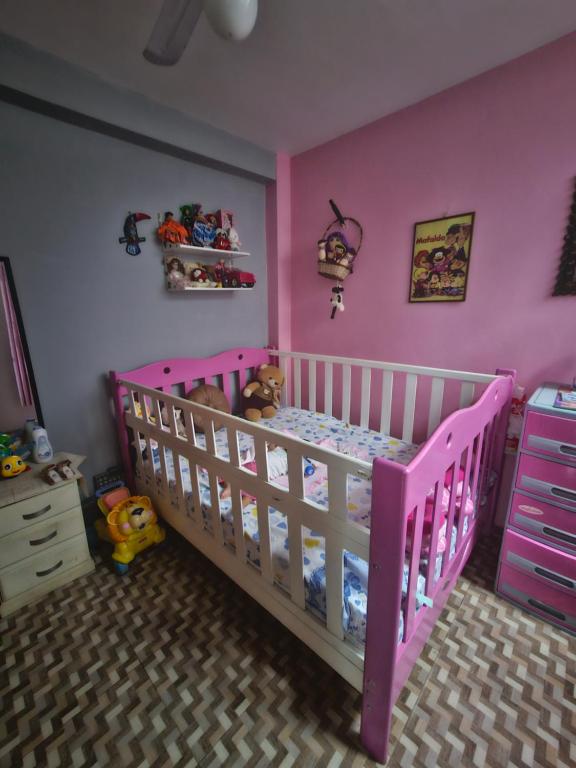 普卡爾帕的住宿－Casa Yarinacocha，粉红色的卧室,配有婴儿床和粉红色的墙壁