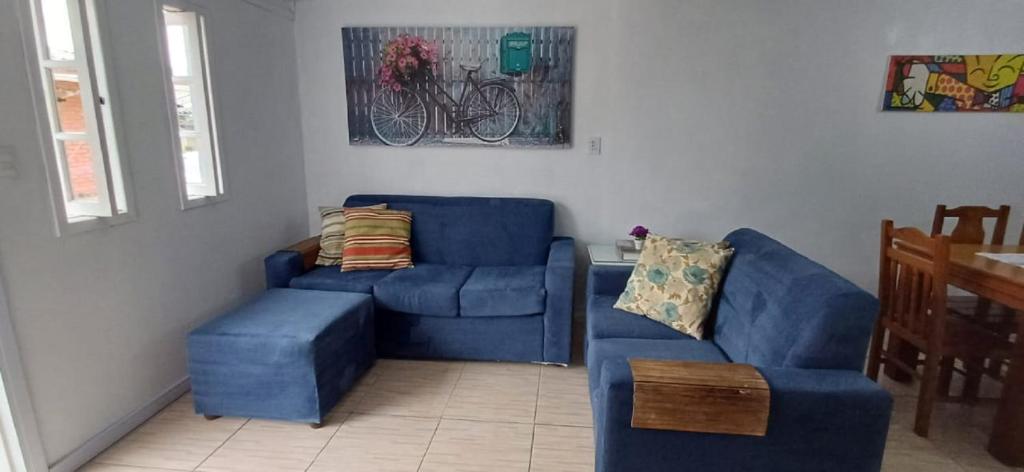 uma sala de estar com um sofá azul e uma cadeira em Residencial P. Harris em Canela