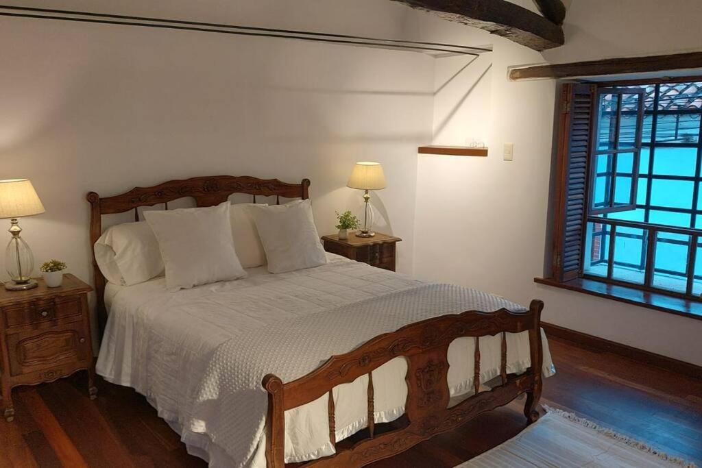 a bedroom with a bed with white sheets and a window at Hermoso y cómodo Departamento a pasos de la plaza in Tarija