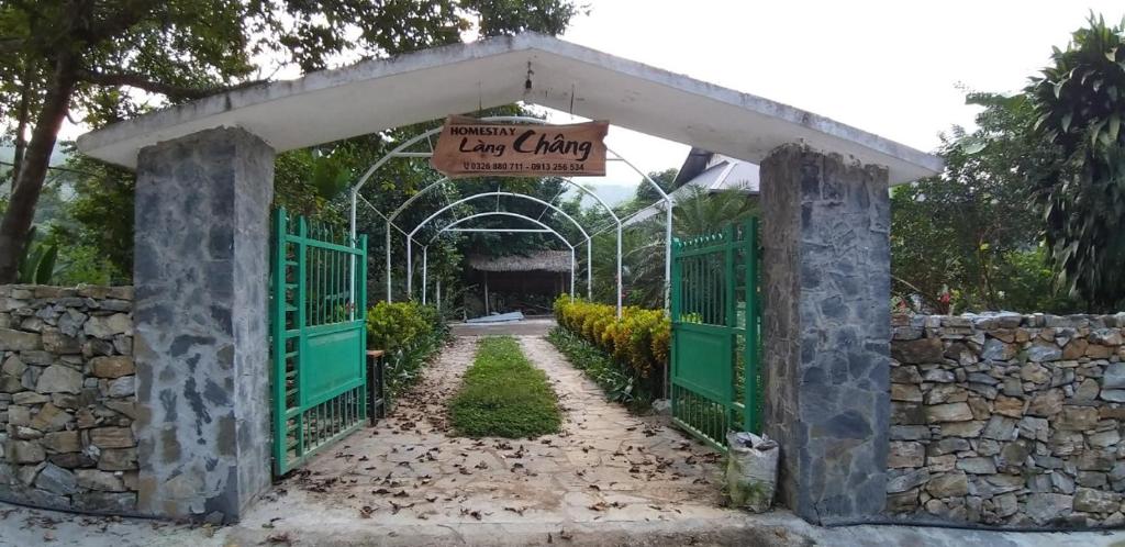 an entrance to a garden with a green gate at Homestay Làng Châng in Ha Giang