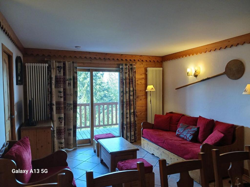 a living room with a red couch and a window at Appartement Les Arcs 1800, 4 pièces, 8 personnes - FR-1-411-909 in Bourg-Saint-Maurice