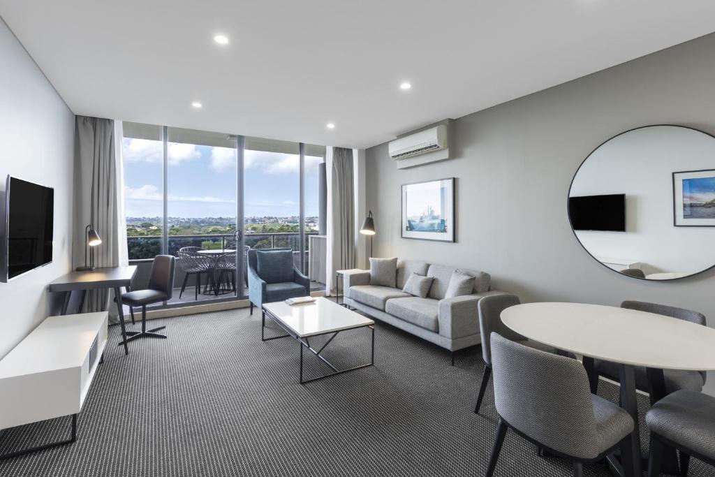 a living room with a couch and a table at Meriton Suites Waterloo in Sydney