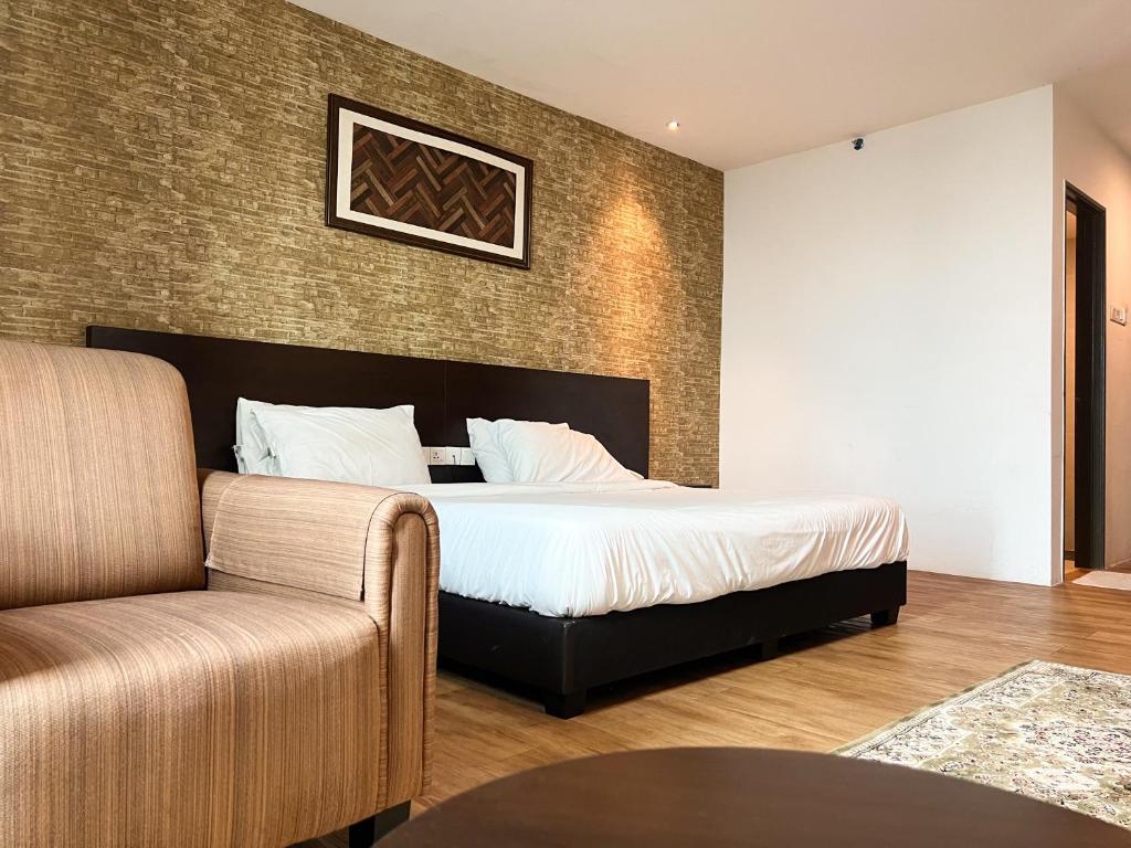 een slaapkamer met een bed en een bank bij Cube Plus Signature Hotel OUG Kuala Lumpur in Kuala Lumpur