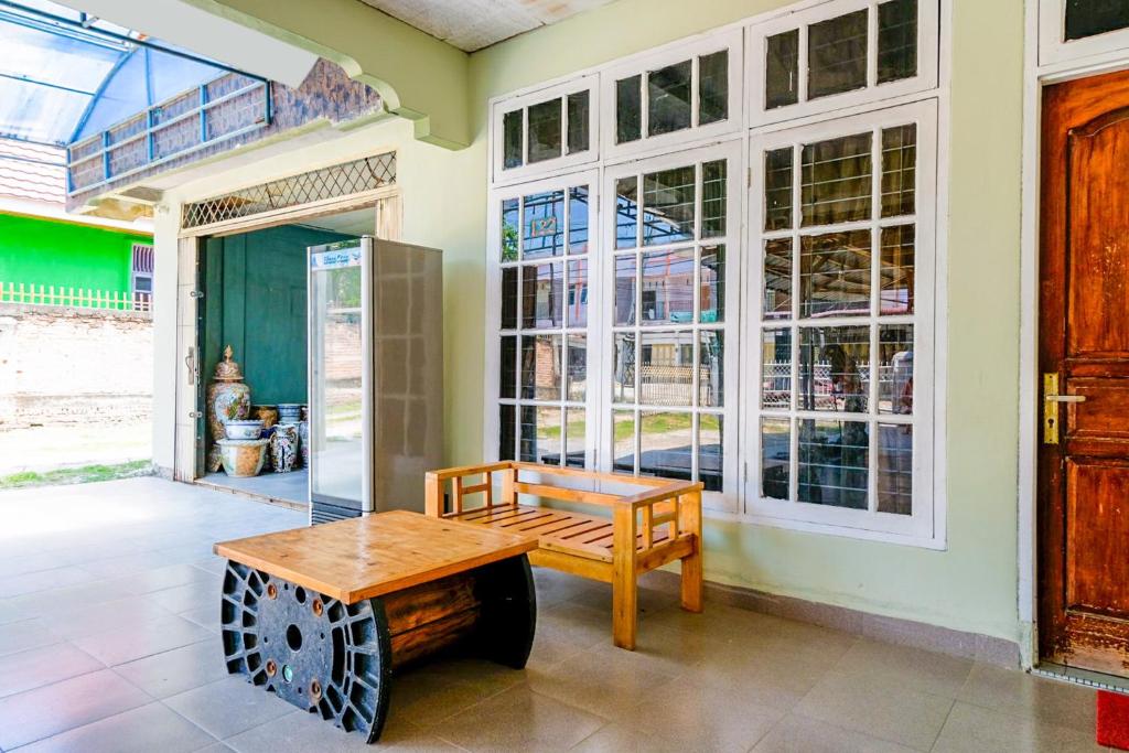 a room with a wooden bench and a table at OYO Life 2745 Nabeza House in Duri