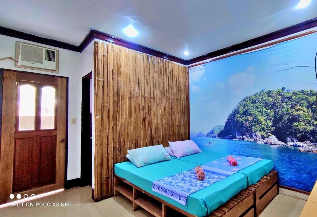 a room with a bed with a view of the ocean at Aquaholik Traveler's Lodge in El Nido