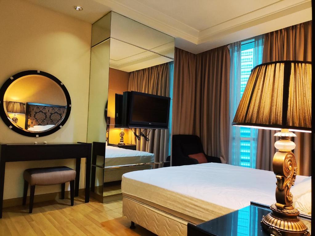 a hotel room with a bed and a mirror at Apartement The Peak Sudirman in Jakarta