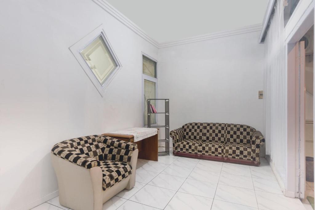 een woonkamer met 2 stoelen en een tafel bij OYO Life 3055 Rumah Enin in Bandung