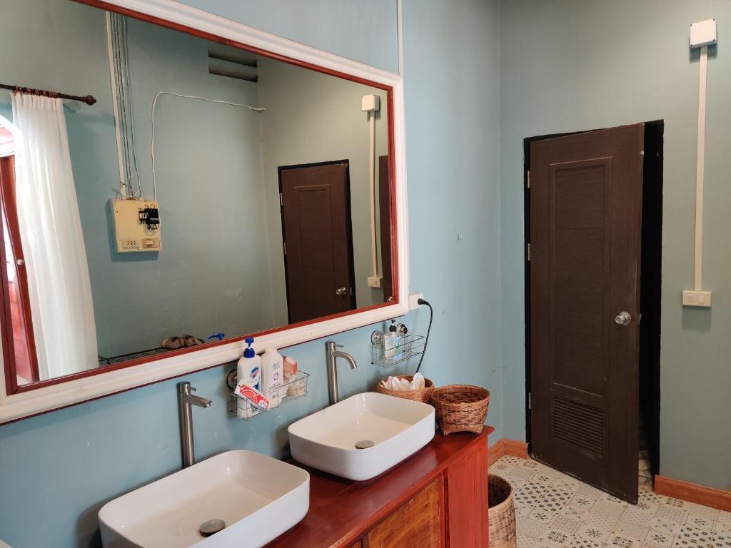 a bathroom with a sink and a large mirror at Via Hostel Pakse in Pakse