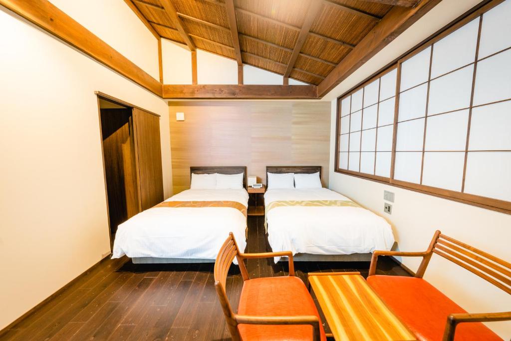 Postel nebo postele na pokoji v ubytování Hotel Rakurakuan