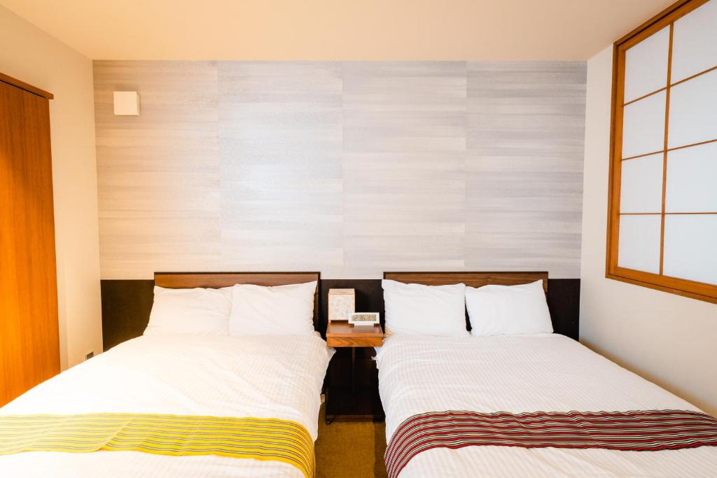 Postel nebo postele na pokoji v ubytování Hotel Rakurakuan