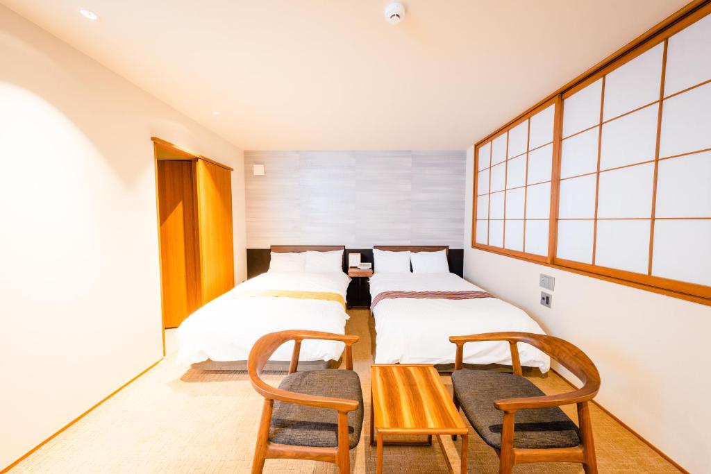 Postel nebo postele na pokoji v ubytování Hotel Rakurakuan