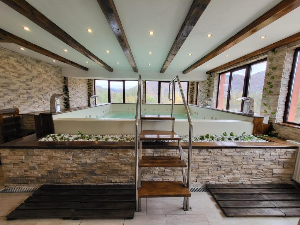 een grote badkamer met een bad en een ladder bij Hotel Bran Stoker in Bran