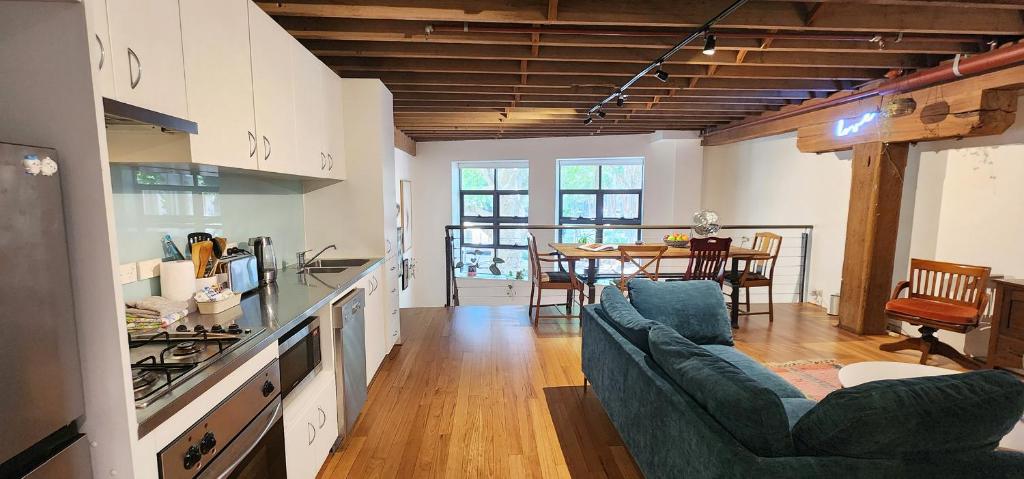 cocina y sala de estar con sofá y mesa en Central New York-Style Loft en Sídney