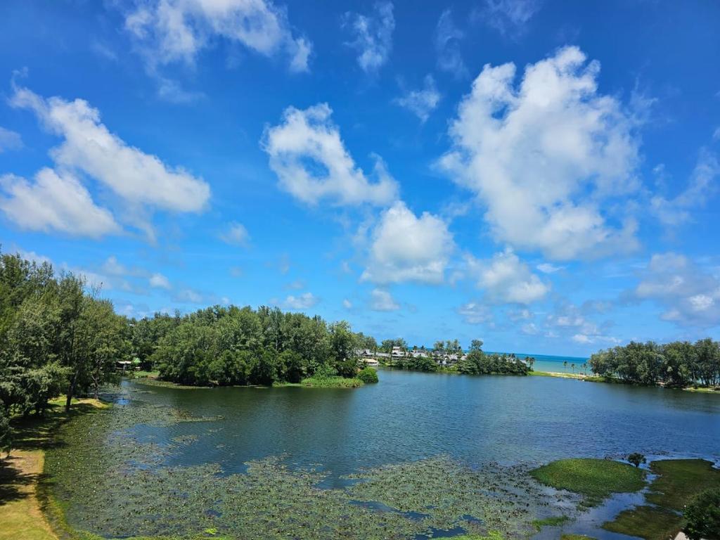 a river with trees and a blue sky with clouds at Cassia Residences 1 in Bang Tao Beach