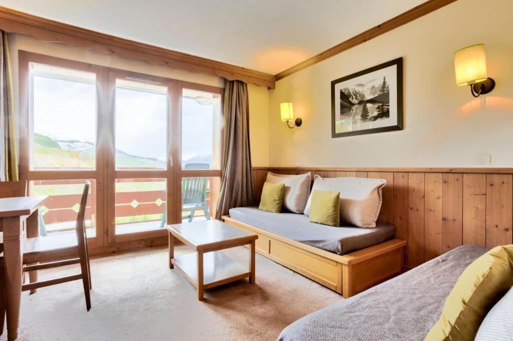 ein Hotelzimmer mit einem Sofa und einem Fenster in der Unterkunft Quartier La Forêt - maeva Home - Appartement 2 pièces 5 personnes - Sélec 134 in Valmorel
