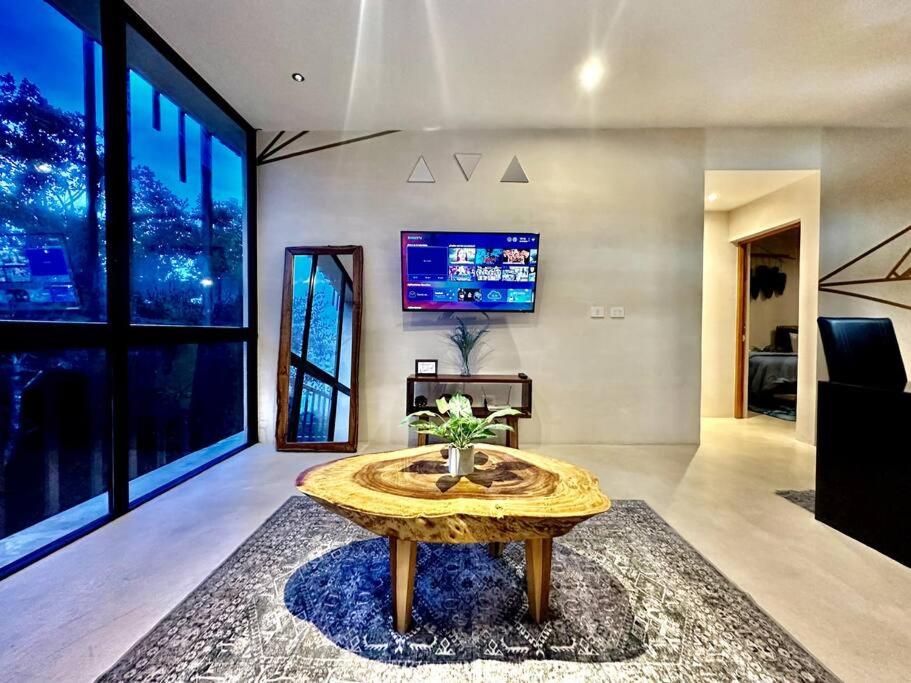 a living room with a table and a tv at *Tulum 2BR w/ Pool, Gym, Security, Walk to Town in Tulum