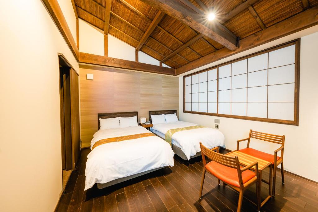 Postel nebo postele na pokoji v ubytování Hotel Rakurakuan