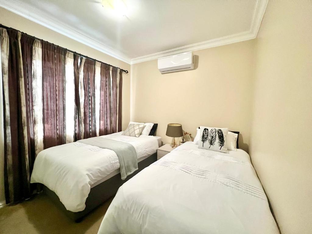 two beds in a small room with a window at Forest View Villa in New Germany