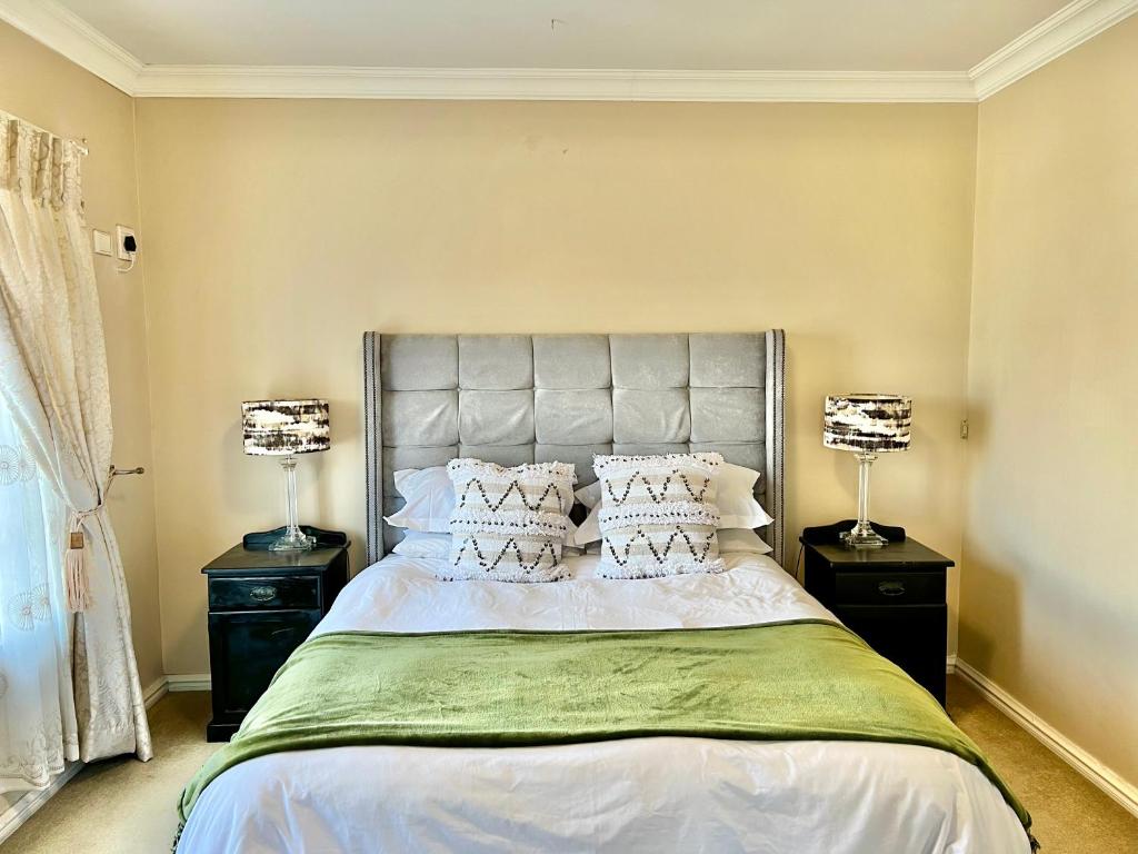 a bedroom with a large bed with two lamps at Forest View Villa in New Germany