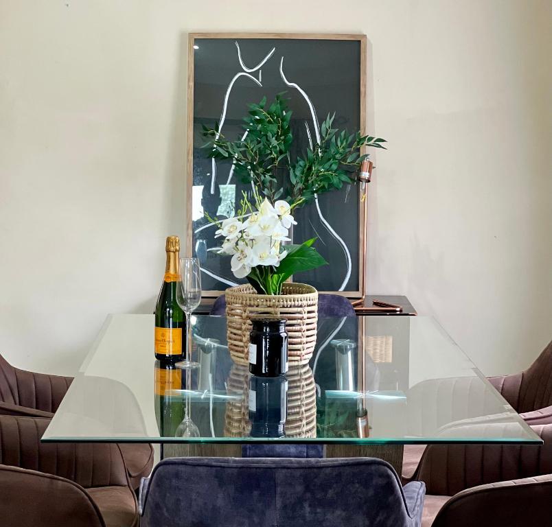 a glass table with a bottle of wine and flowers at Forest View Villa in New Germany