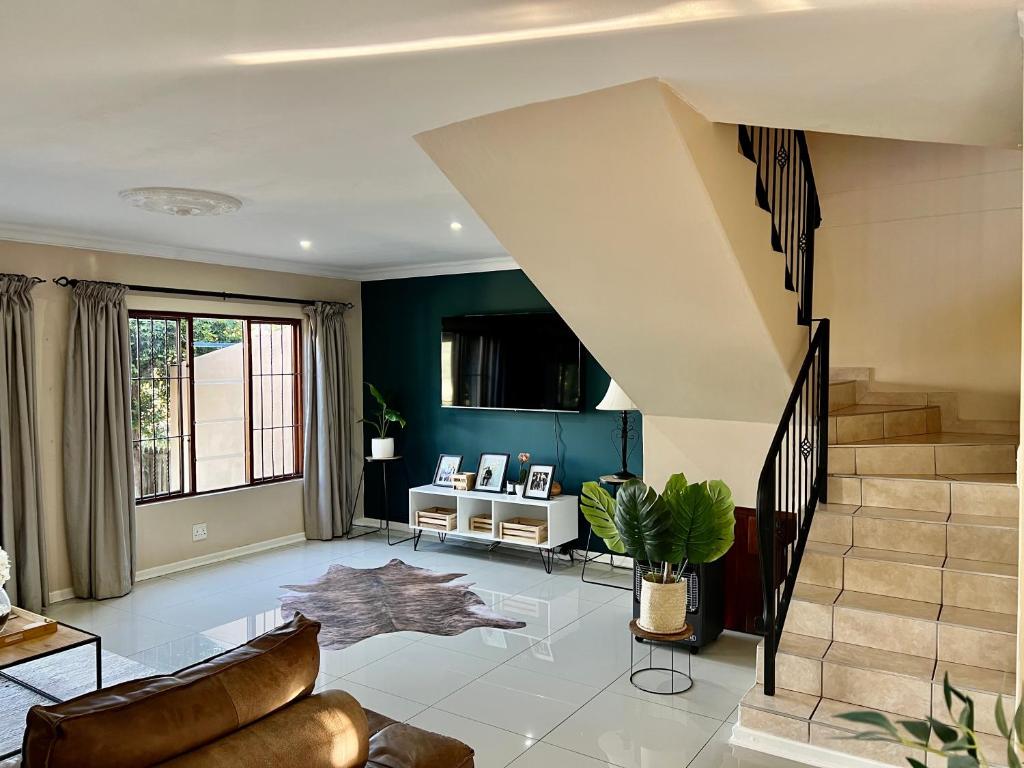 a living room with a staircase and blue walls at Forest View Villa in New Germany