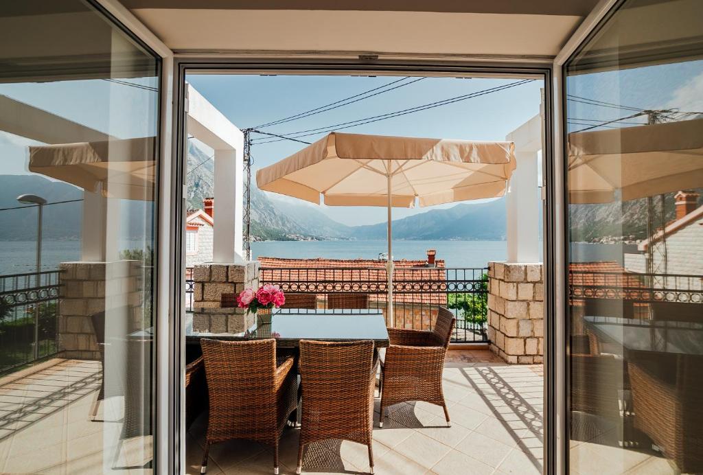 a patio with a table and chairs and an umbrella at Holiday Home Amanda Hollick in Kotor