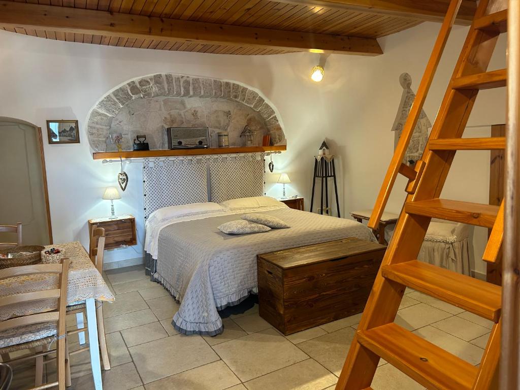 a bedroom with a large bed and a ladder at Trullo Delle Sorelle in Alberobello