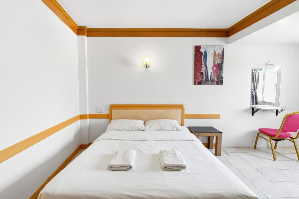 - une chambre avec un lit et deux chaises roses dans l'établissement Phu Inn Hotel, à Khon Kaen
