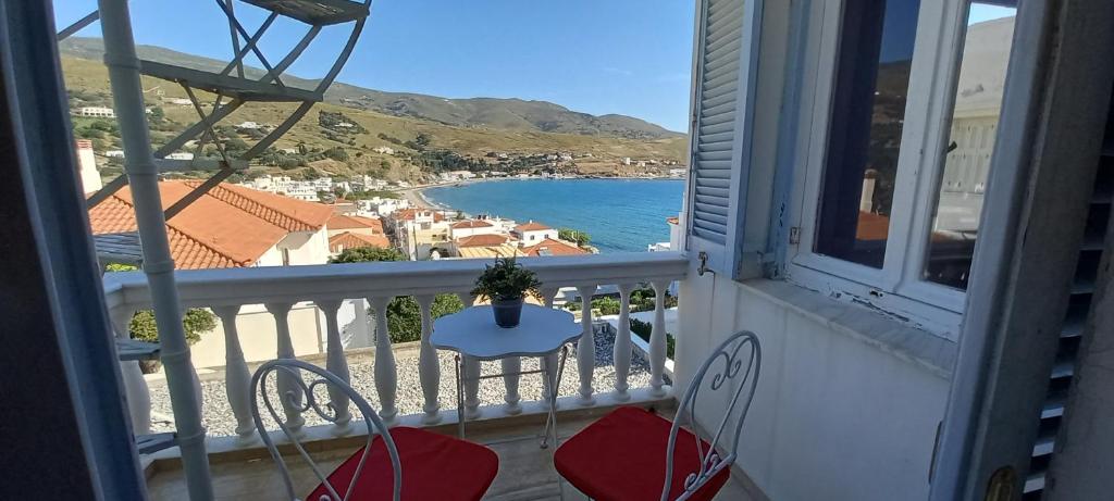 a balcony with a table and chairs and a view of the ocean at GEORGE HOME in Andros