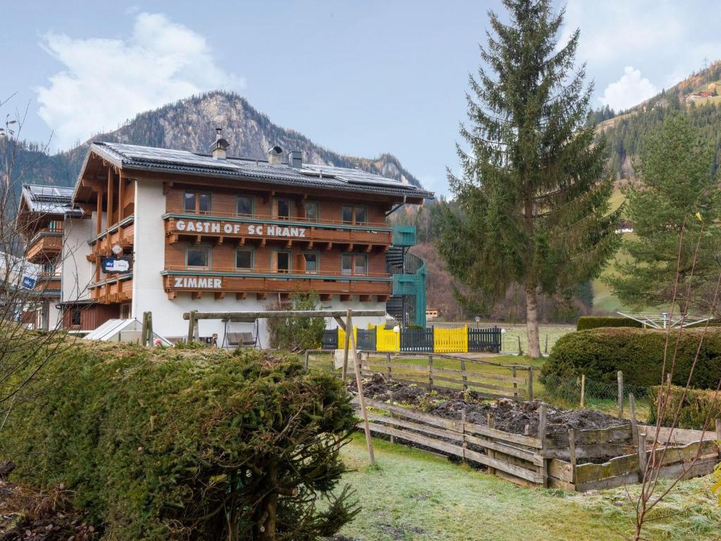 ein Gebäude mit einem Zaun davor in der Unterkunft Lovely Apartment with Sauna Ski Storage Pool Terrace in Wald im Pinzgau