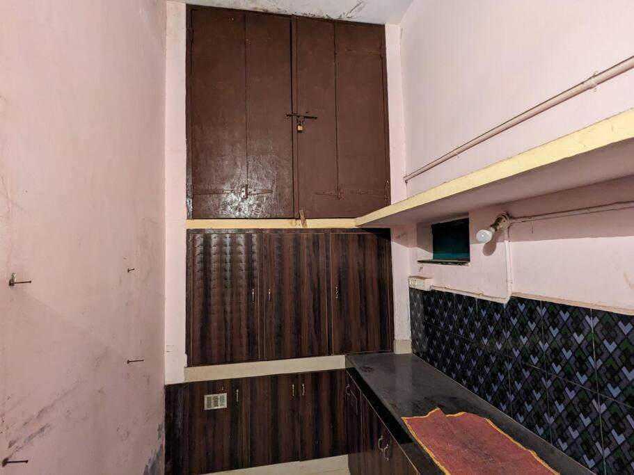 an empty room with two wooden doors and a wall at Padmini Nivas in Brahmapur