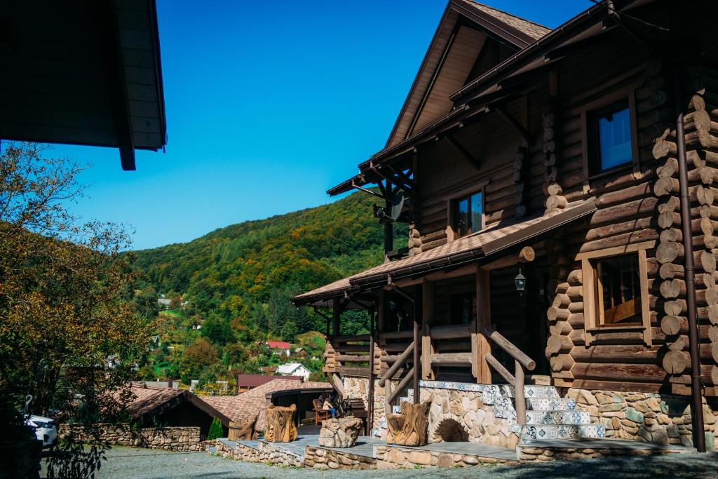 a log cabin with a mountain in the background at BRB Park Hotel in Vizhenka