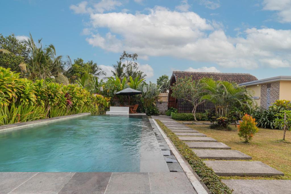 a swimming pool in the backyard of a house at Kubu Selat Villa and Glamping in Gianyar