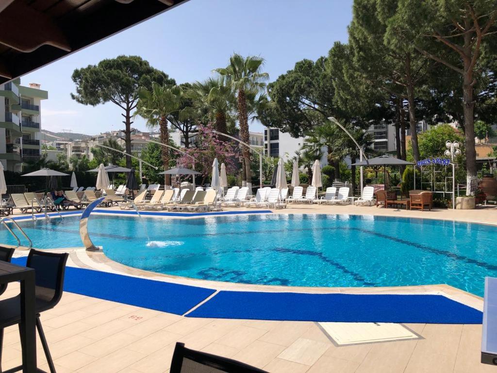 a large swimming pool with chairs and umbrellas at Opus Apart Hotel in Kusadası