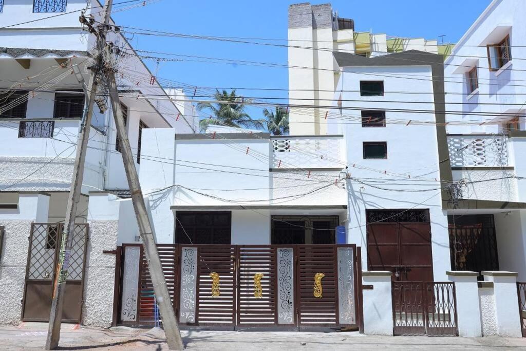 a white building with a wooden gate in front of it at Heritage home with 3 bed/3 bath with kitchen in a residential neighborhood. in Madurai