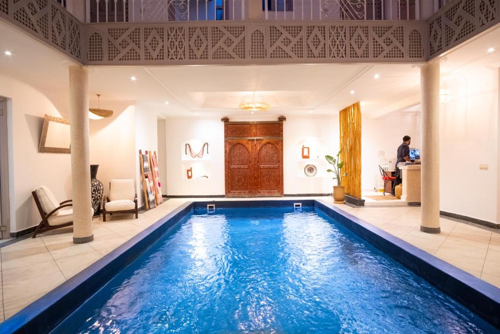 una gran piscina en una habitación con una casa en Riad Bibazia, en Marrakech