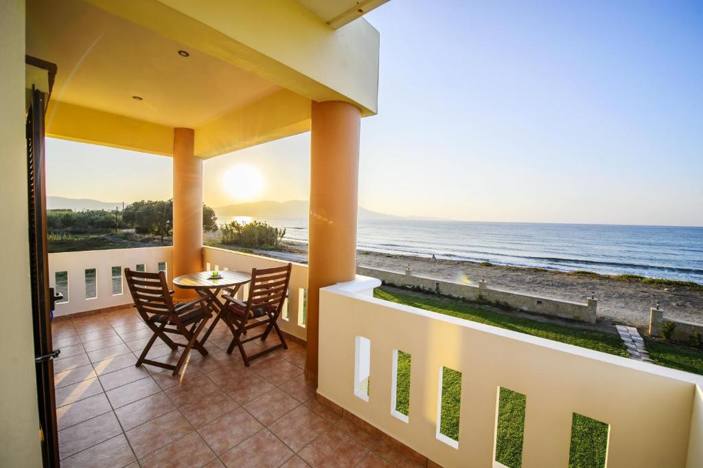 a balcony with a table and chairs and the ocean at Niriides Apartments in Kissamos