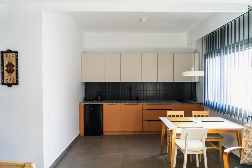 a kitchen with a table and chairs and a dining room at Ba & Bu Apartment 1 in Katerini