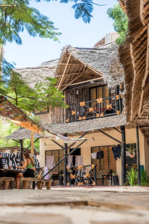 a house with a thatched roof and a patio at Makofi Guest House in Nungwi