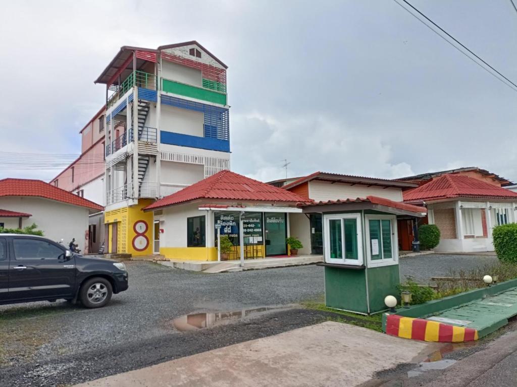 un coche aparcado en un aparcamiento frente a un edificio en โรงแรมแอมไอม่อน - Am Amoonds Hotel en Khlung