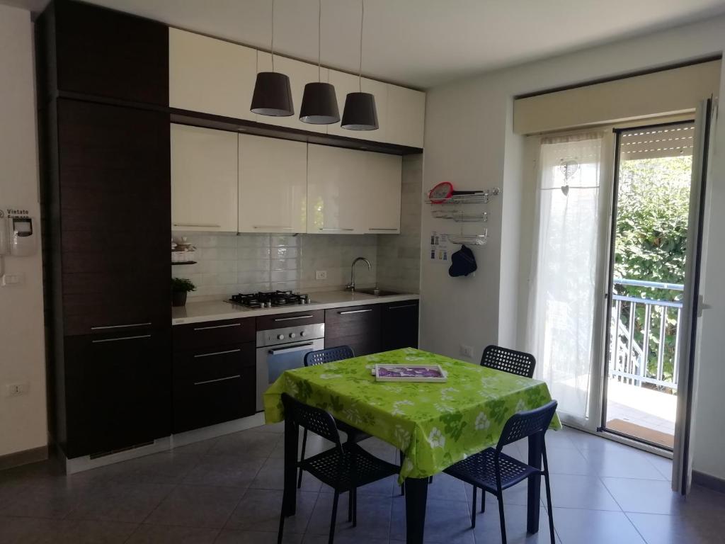 Casa MaryGiò في سان جوفاني تياتينو: مطبخ مع طاولة عليها قطعة قماش من الطاولة الخضراء