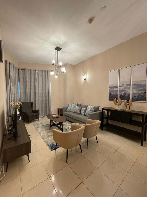 ein Wohnzimmer mit einem Sofa und einem Tisch in der Unterkunft Marbella Grand Holiday Homes - Al Nahda 1 in Dubai