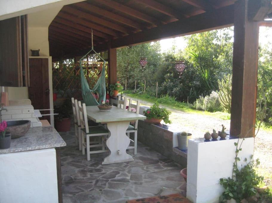 a patio with a table and chairs under a pavilion at ROBY’s NEST in Maracalagonis