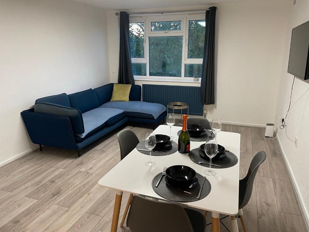 a living room with a table and a blue couch at Modern big 2 bedroom in Northolt with terrace parking in Northolt