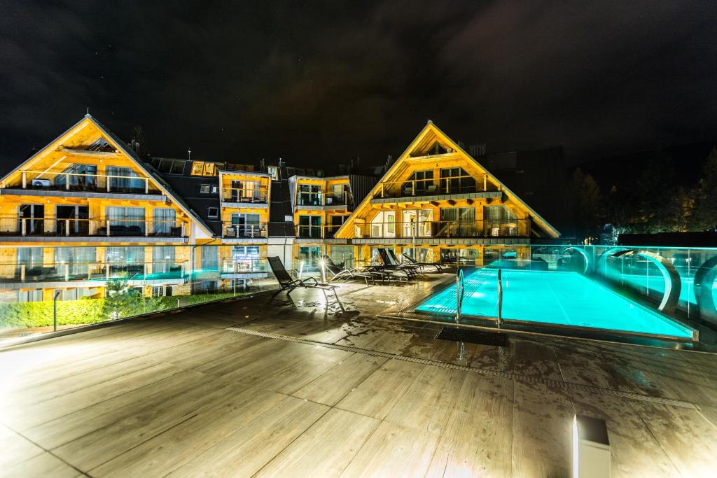 a large building with a swimming pool at night at Apartamenty Royal Resort Spa in Zakopane