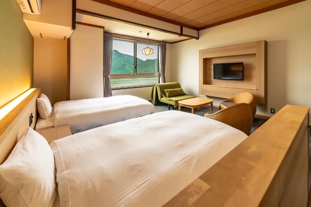 Postel nebo postele na pokoji v ubytování Ooedo Onsen Monogatari Premium Kinosaki