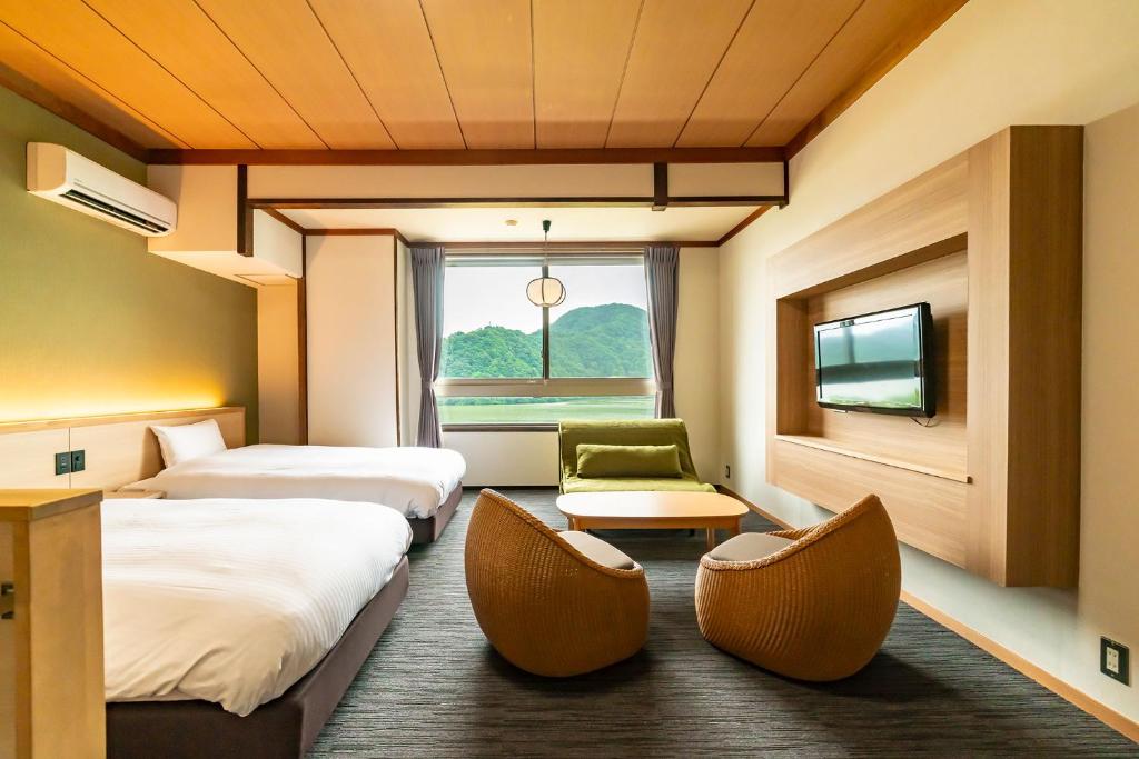 Postel nebo postele na pokoji v ubytování Ooedo Onsen Monogatari Premium Kinosaki