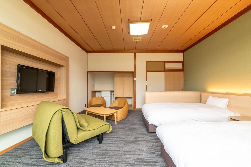 Postel nebo postele na pokoji v ubytování Ooedo Onsen Monogatari Premium Kinosaki